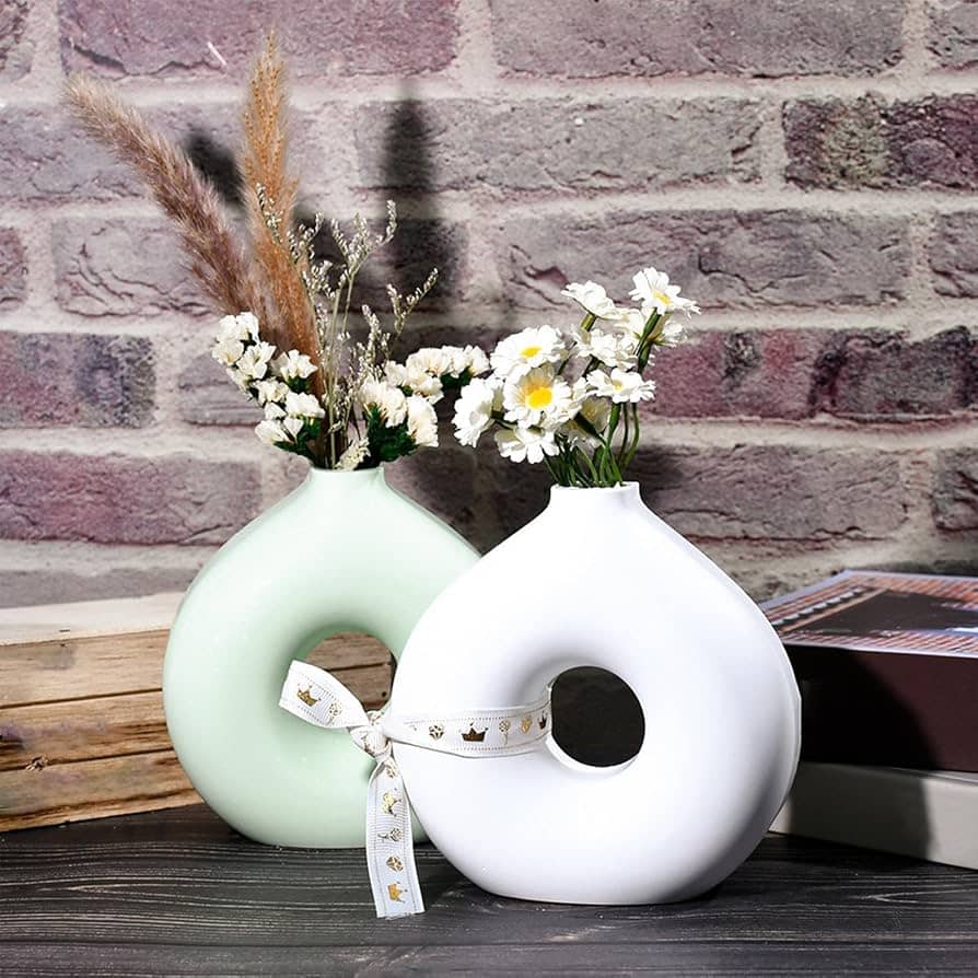 Two rounded sculptural vases styled with flowers